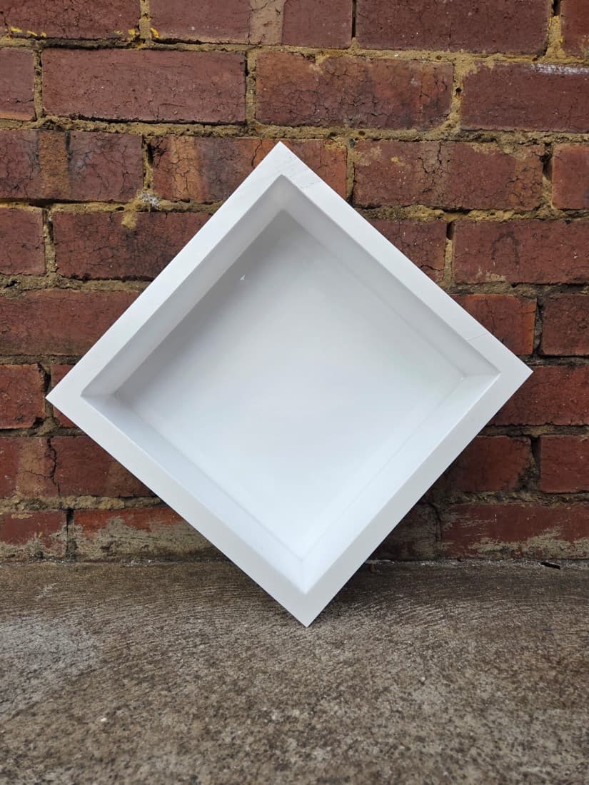 White acrylic recessed box tray fabricated for a building fit-out, shown against a brick wall