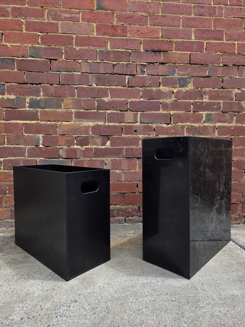 Pair of fabricated black plastic storage bins with cut handle slots