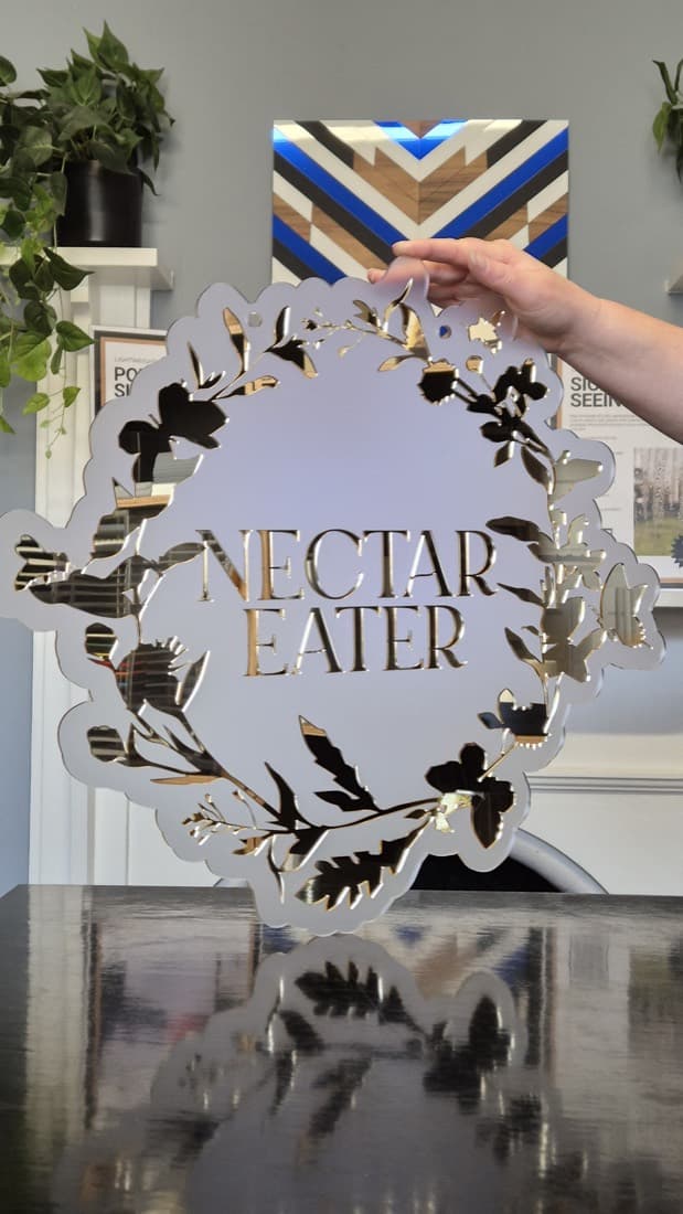 Gold mirror-acrylic floral plaque reading Nectar Eater, a laser-cut decorative sign